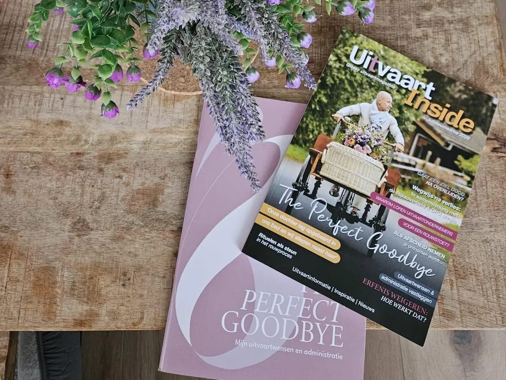 Uitvaart-Inside en The Perfect Goodbye op een houten tafel met bloemen