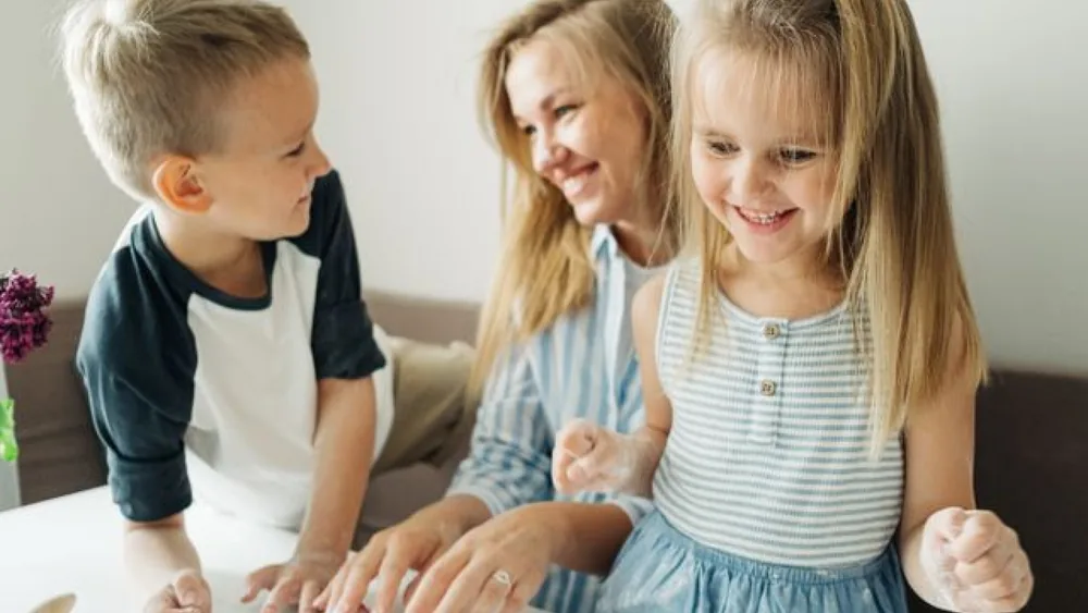 Een moeder zit met haar kinderen aan tafel