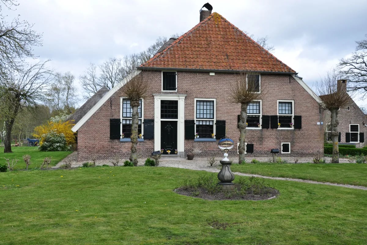 een rustig en sereen Nederlands landschap met een huis op de achtergrond