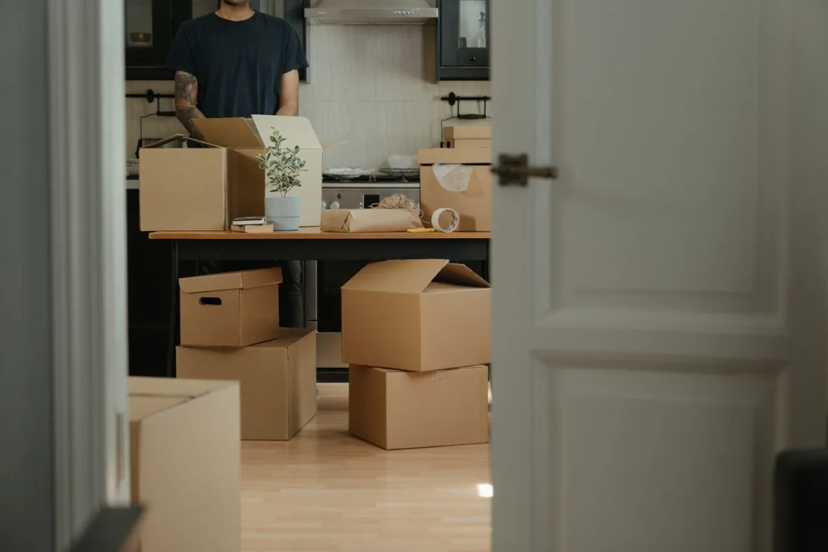 Een persoon helpt een ouder iemand bij het inpakken van hun spullen om naar een nieuw huis te verhuizen.